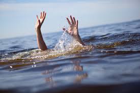 person in the water, arms are waving above the water